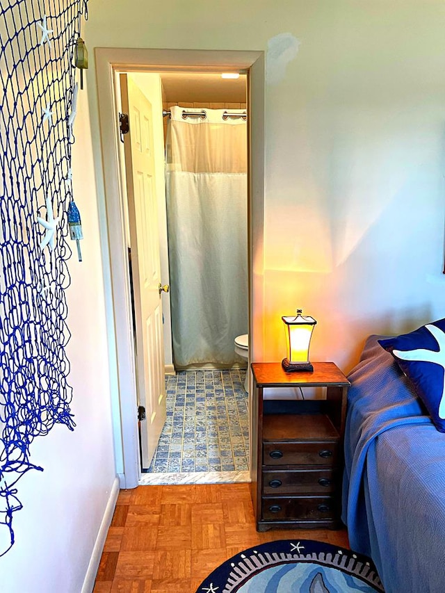 bedroom featuring connected bathroom and parquet floors