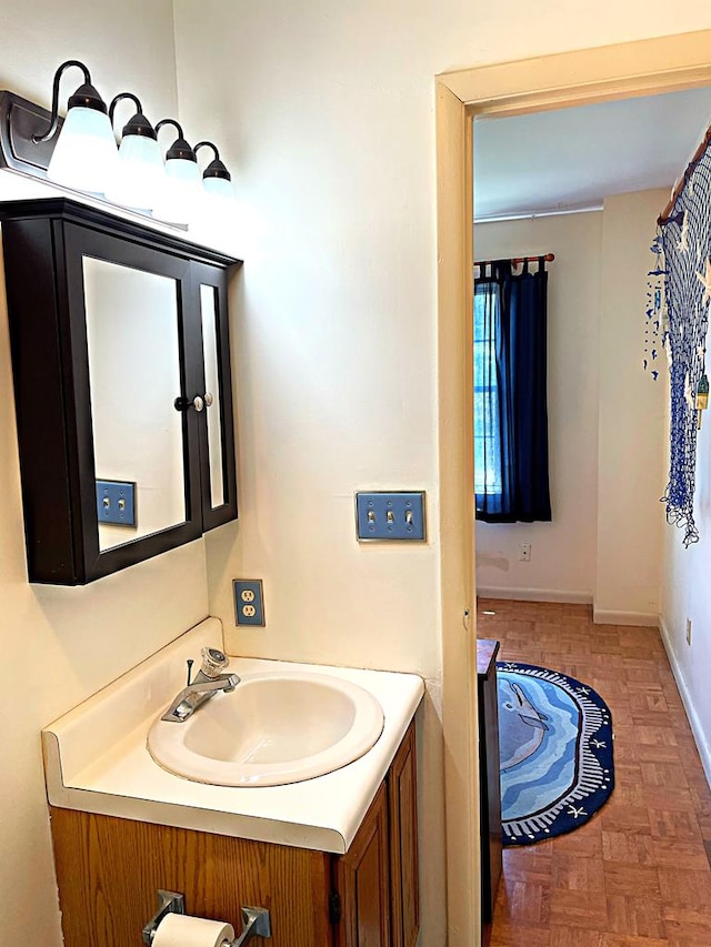 bathroom featuring parquet flooring and vanity