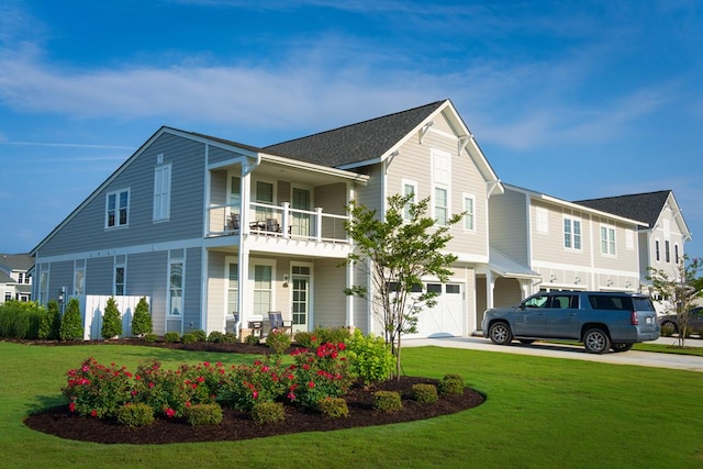 view of front of house with a balcony, a front yard, and a garage