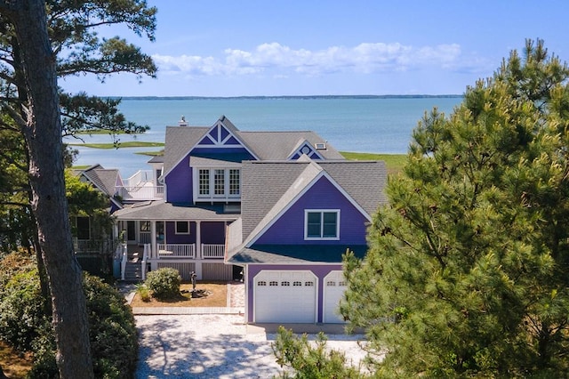 5095 Blake Point Rd, Chincoteague, VA 23336 - view of front of home with roof with shingles, concrete driveway, a water view, and an attached garage