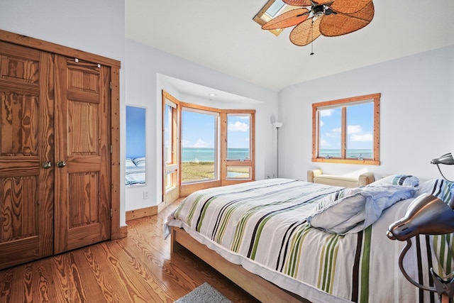5095 Blake Point Rd, Chincoteague, VA 23336 - bedroom with wood finished floors, multiple windows, a ceiling fan, and a water view