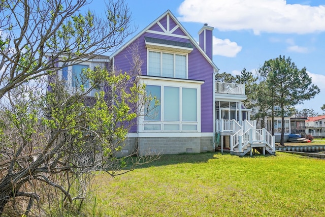 5095 Blake Point Rd, Chincoteague, VA 23336 - view of front of house with a sunroom, a chimney, a front lawn, stairway, and a balcony