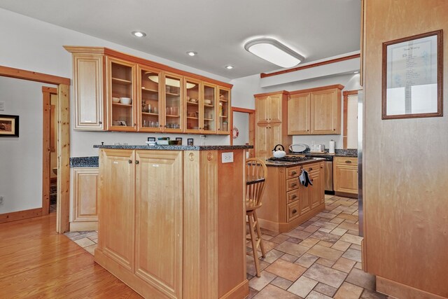 5095 Blake Point Rd, Chincoteague, VA 23336 - kitchen featuring glass insert cabinets, a kitchen island, recessed lighting, dark stone countertops, and a kitchen breakfast bar