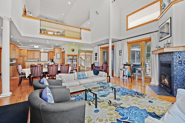 5095 Blake Point Rd, Chincoteague, VA 23336 - living area with ornate columns, light wood-style floors, a high ceiling, a tile fireplace, and recessed lighting