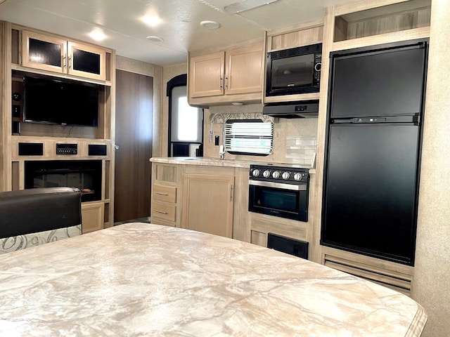 kitchen with wall oven, glass insert cabinets, refrigerator, light brown cabinets, and black microwave