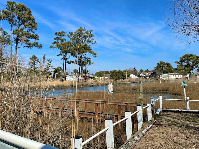 view of dock with a water view and fence