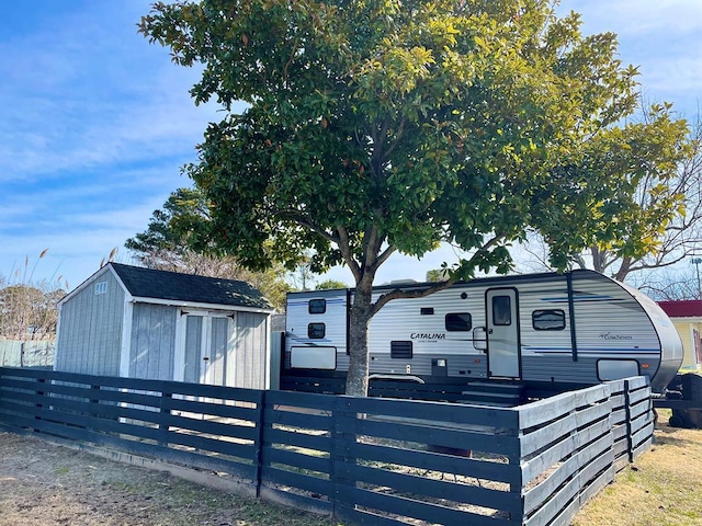 view of front of house featuring a storage shed, fence, and an outbuilding