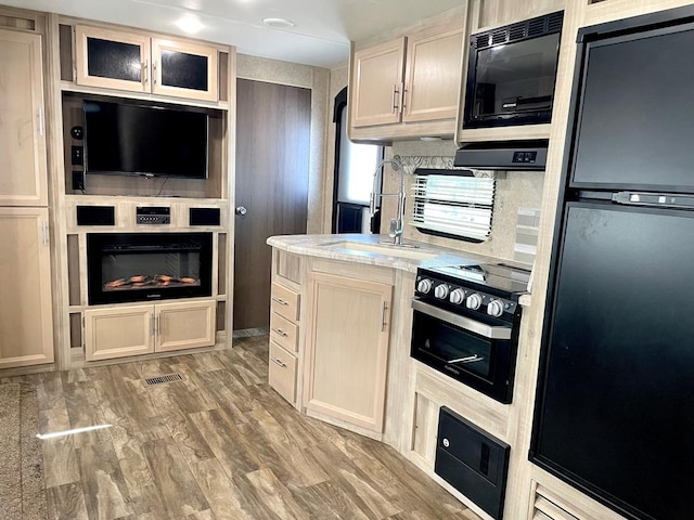 kitchen featuring refrigerator, black range with electric stovetop, a sink, built in microwave, and glass insert cabinets