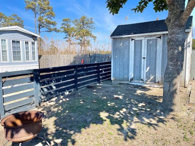 view of yard featuring an outbuilding, a fenced backyard, and a shed