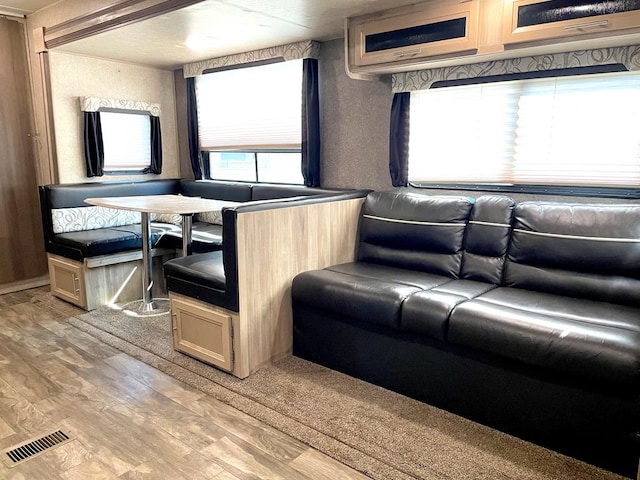 interior space with a textured wall, light wood finished floors, and visible vents