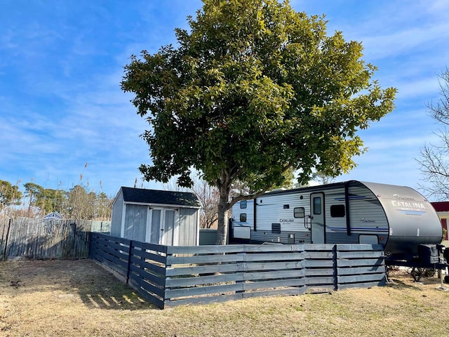 exterior space featuring an outbuilding, a storage unit, and fence