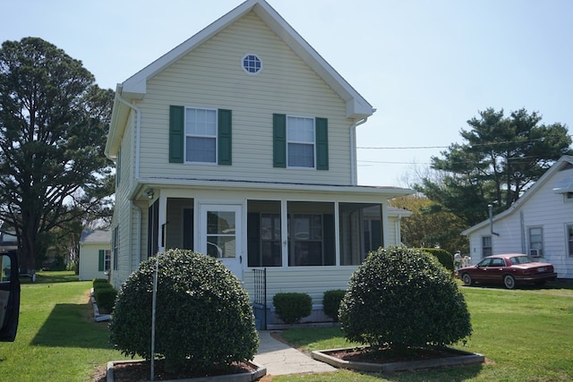 view of front of house with a sunroom and a front yard