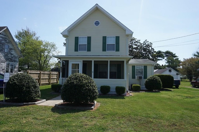 rear view of property featuring a sunroom and a lawn