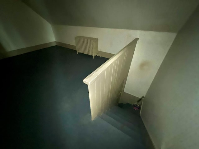 stairway with vaulted ceiling and radiator heating unit