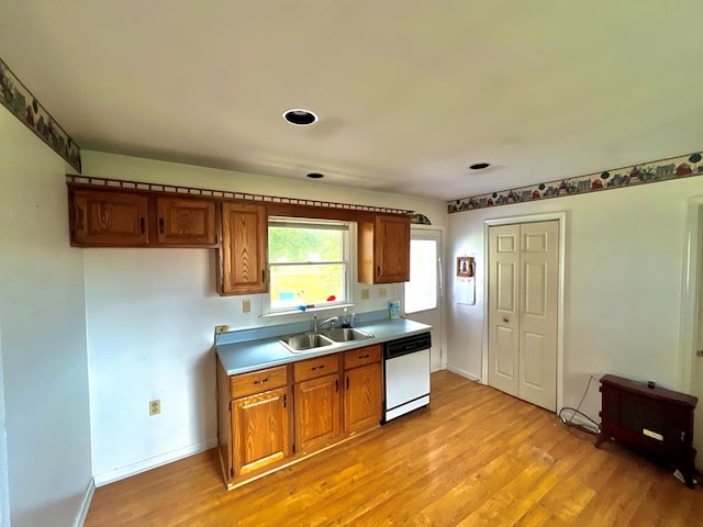 kitchen featuring a sink, light wood-style floors, brown cabinetry, and dishwasher