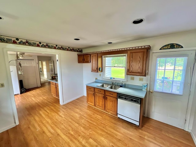 kitchen featuring brown cabinets, white dishwasher, and light wood-type flooring