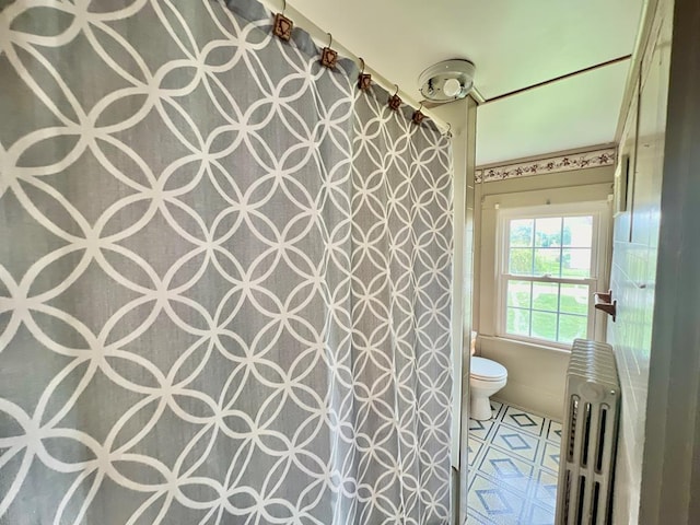 bathroom featuring radiator, toilet, and a shower with shower curtain