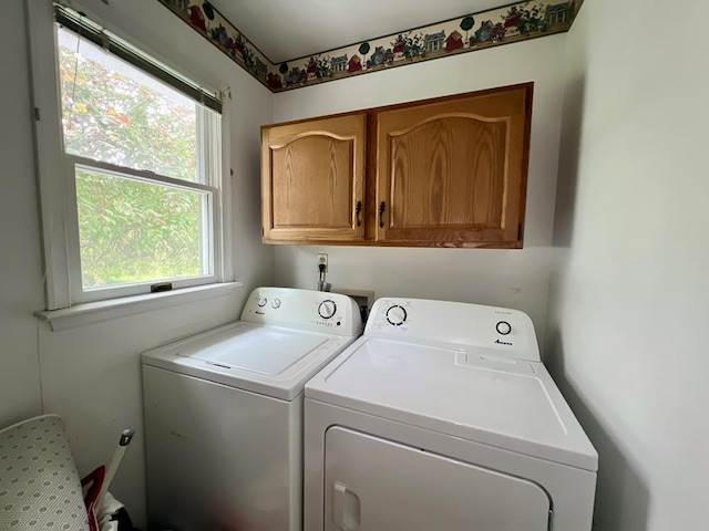 washroom featuring cabinet space, washer and dryer, and a healthy amount of sunlight