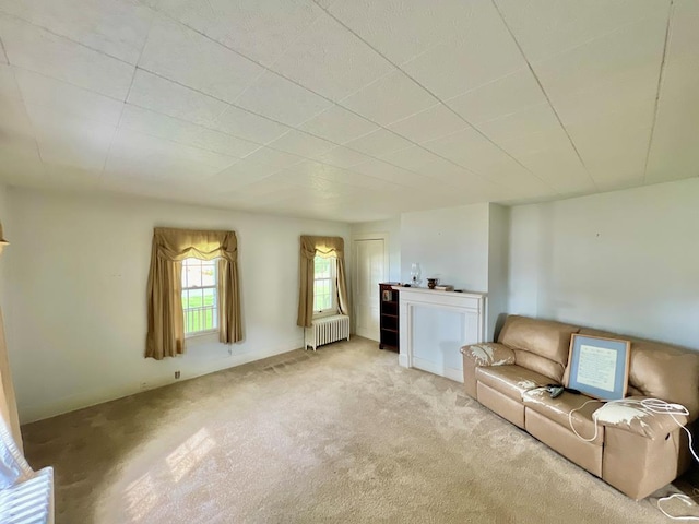 unfurnished living room featuring radiator heating unit and light carpet