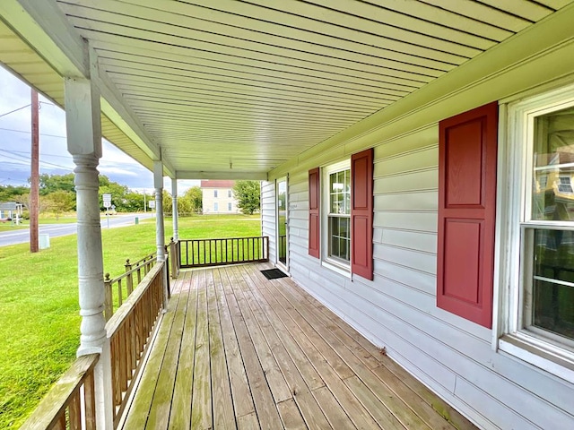 wooden terrace featuring a yard and a porch