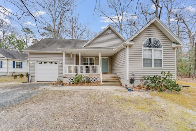 single story home featuring covered porch, driveway, a shingled roof, and an attached garage