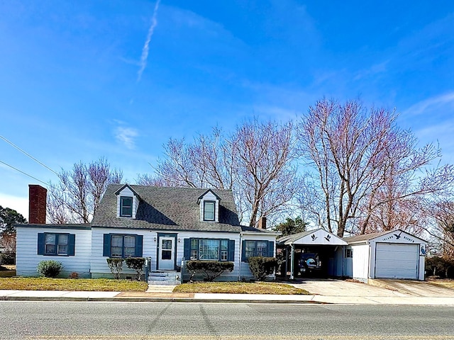6136 Maddox Blvd, Chincoteague, VA 23336 - cape cod-style house featuring a shingled roof, an outdoor structure, concrete driveway, a carport, and a detached garage