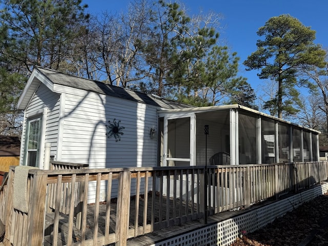 view of side of home featuring a wooden deck and a sunroom