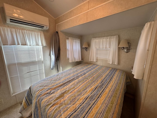 bedroom with lofted ceiling and a wall unit AC