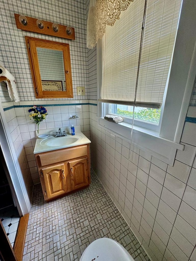 bathroom with tile patterned flooring, vanity, and tile walls