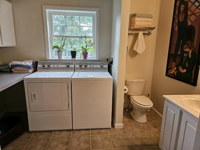 clothes washing area featuring separate washer and dryer, tile patterned flooring, and sink