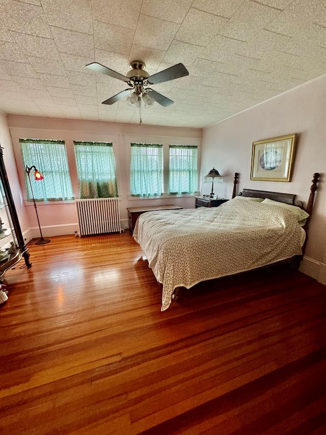 bedroom with radiator, ceiling fan, and light wood-type flooring