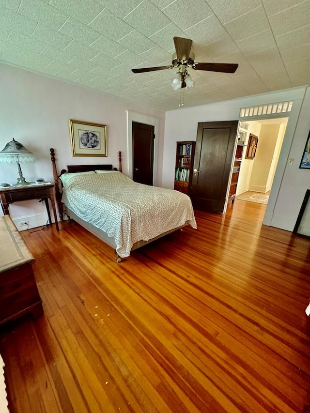 bedroom with ceiling fan and wood-type flooring