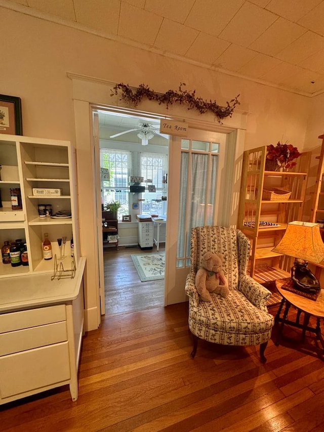 sitting room with ceiling fan and hardwood / wood-style flooring