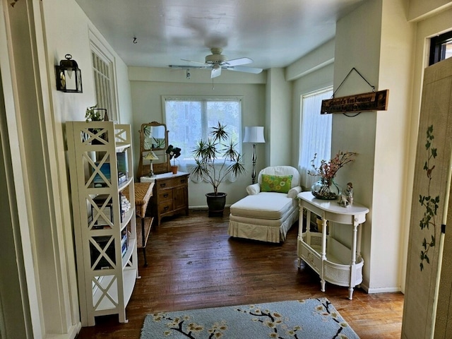 living area with dark hardwood / wood-style flooring and ceiling fan