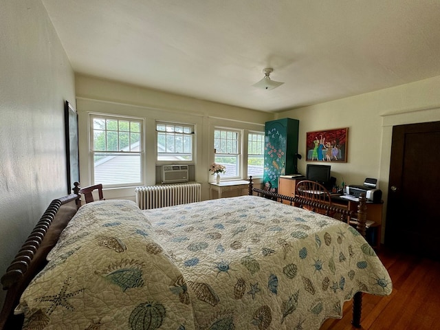 bedroom with wood-type flooring, radiator, and cooling unit