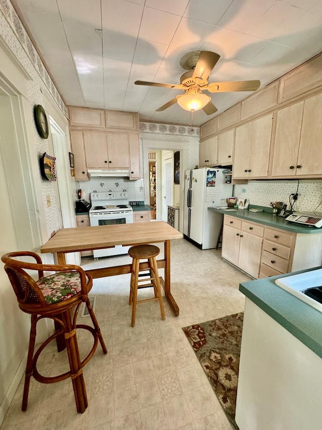 kitchen with decorative backsplash, ceiling fan, light brown cabinets, and white appliances