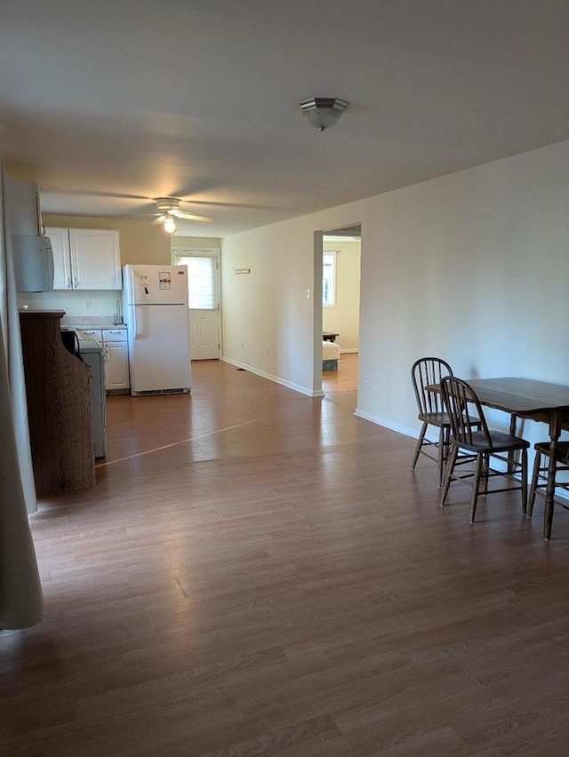 unfurnished dining area featuring hardwood / wood-style flooring and ceiling fan