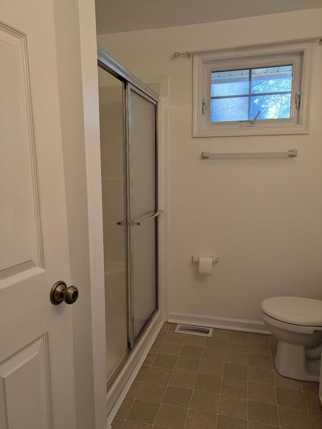 bathroom with toilet and a shower with door