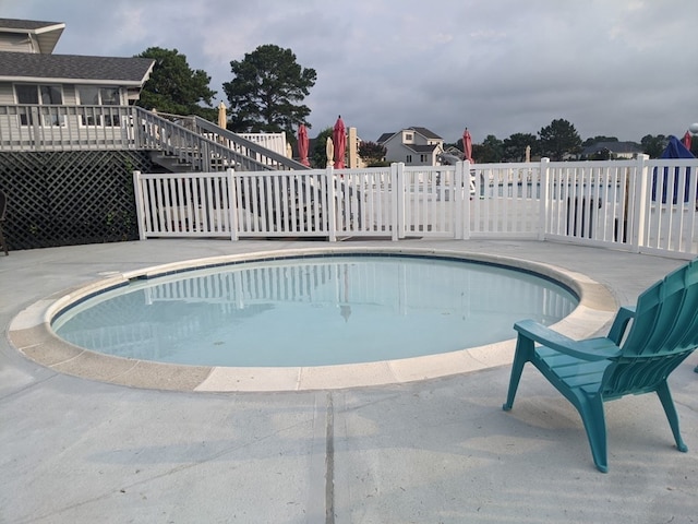 view of swimming pool featuring a wooden deck and a patio area