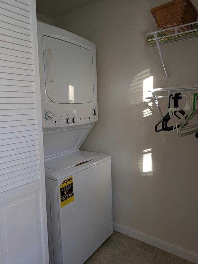 clothes washing area featuring stacked washer / drying machine and light tile patterned floors