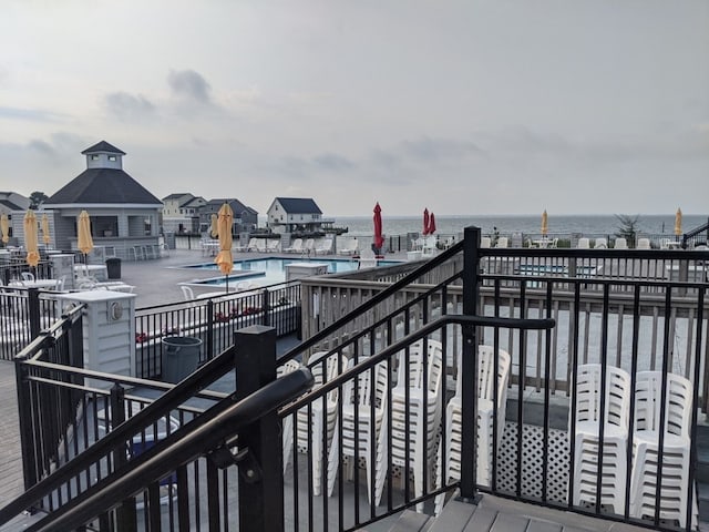 wooden deck with a water view and a community pool