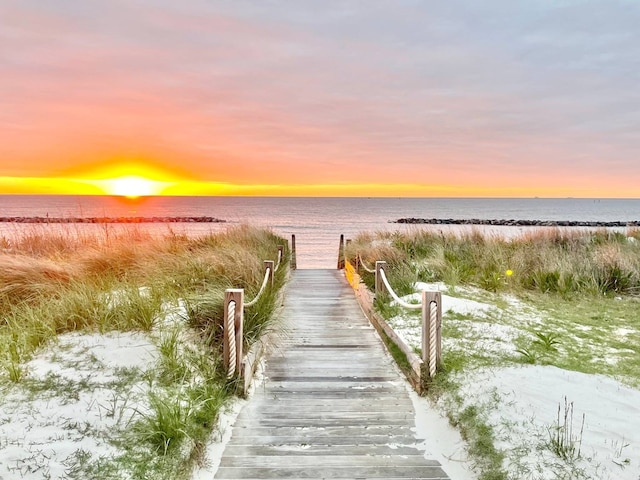 view of dock featuring a view of the beach and a water view