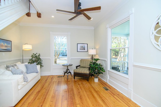 living area with light hardwood / wood-style flooring, plenty of natural light, and ornamental molding