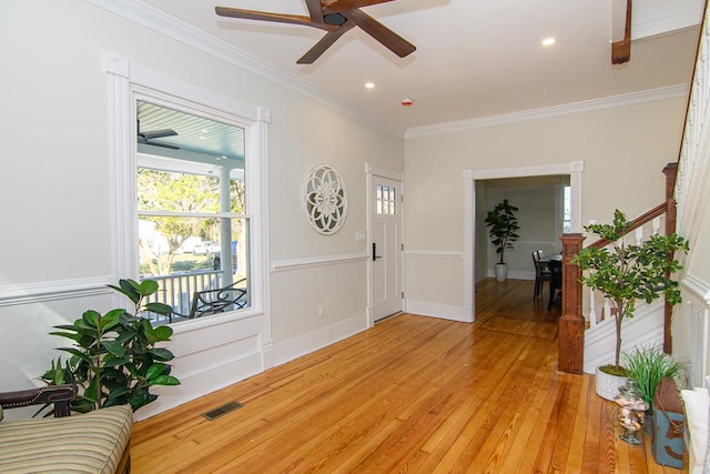 foyer with ceiling fan, light wood-type flooring, and ornamental molding