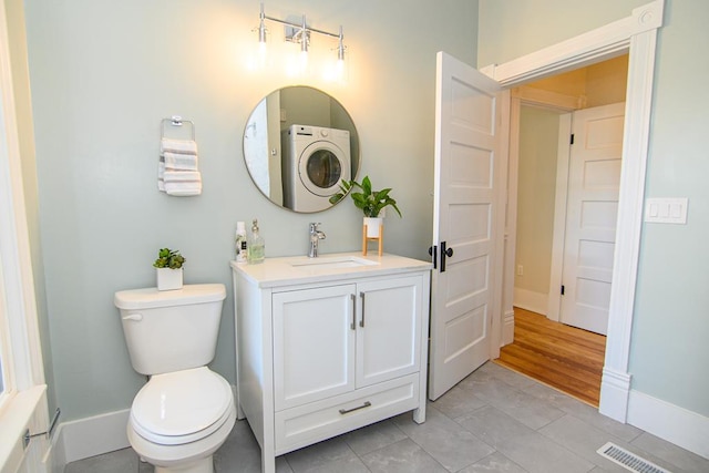 bathroom featuring tile patterned floors, vanity, washer / clothes dryer, and toilet