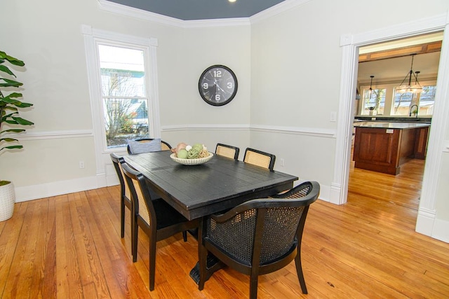 dining room featuring light wood-type flooring and ornamental molding