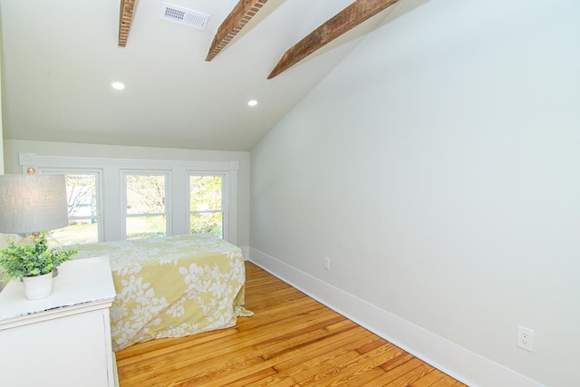 bedroom with hardwood / wood-style floors and lofted ceiling with beams