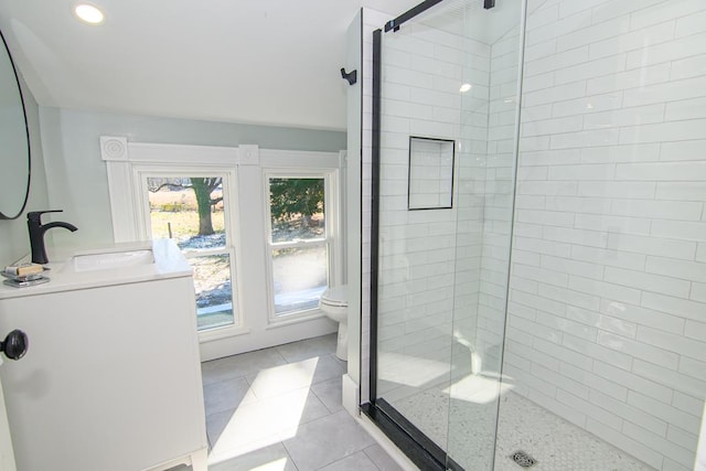 bathroom featuring tile patterned flooring, washer / clothes dryer, toilet, and an enclosed shower