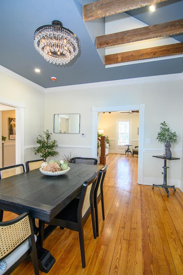 dining room with a chandelier, ornamental molding, and light wood-type flooring