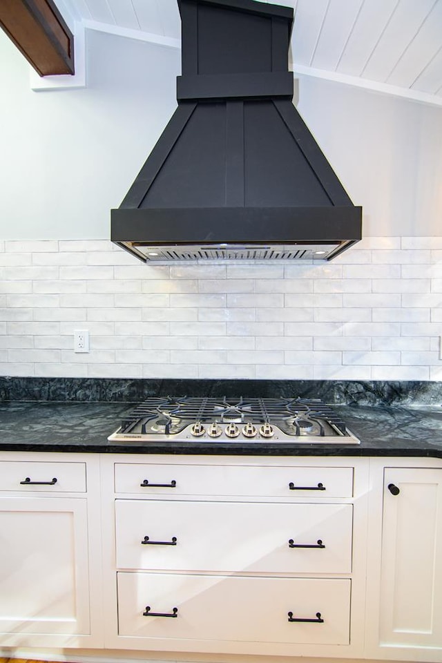 kitchen featuring white cabinets, backsplash, stainless steel gas cooktop, and custom exhaust hood